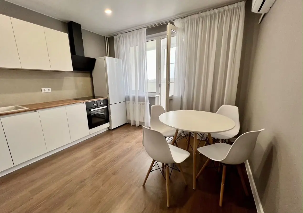 Cocina comedor blanca con suelo de madera