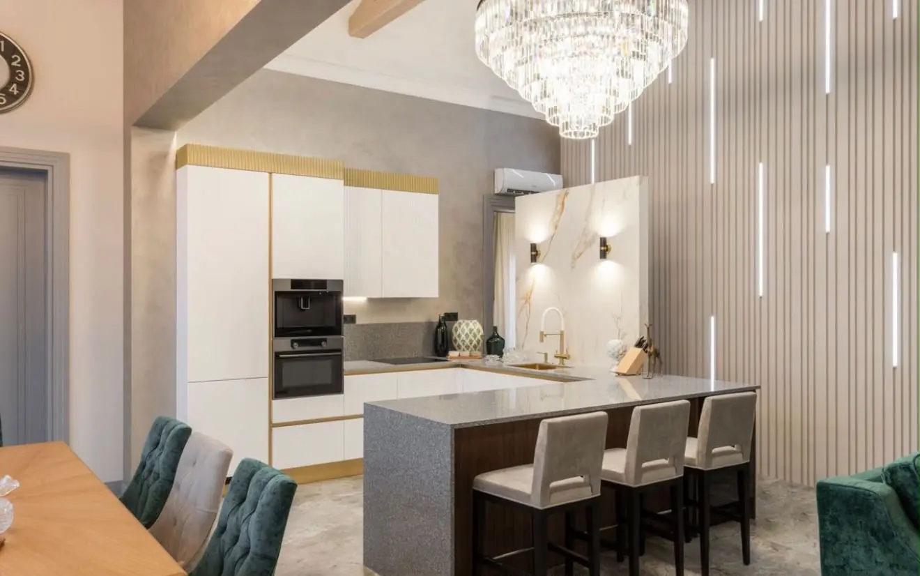 Cocina contemporánea blanca con isla de piedra